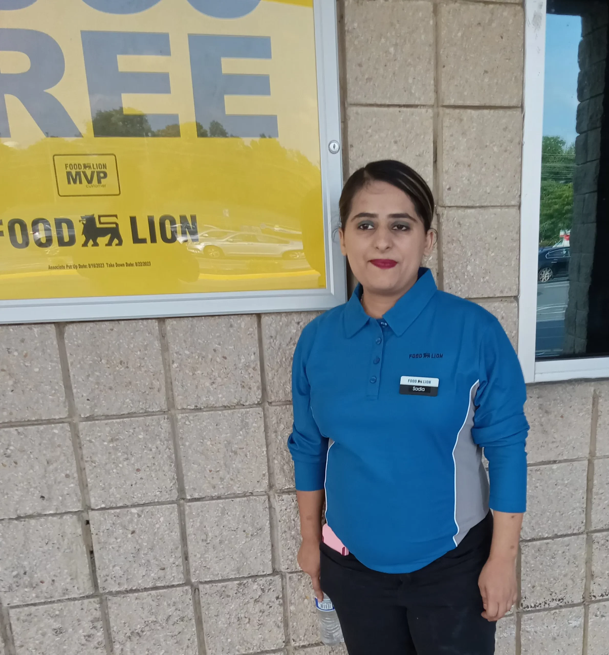 photo of woman in food lion uniform standing in front of food lion sign